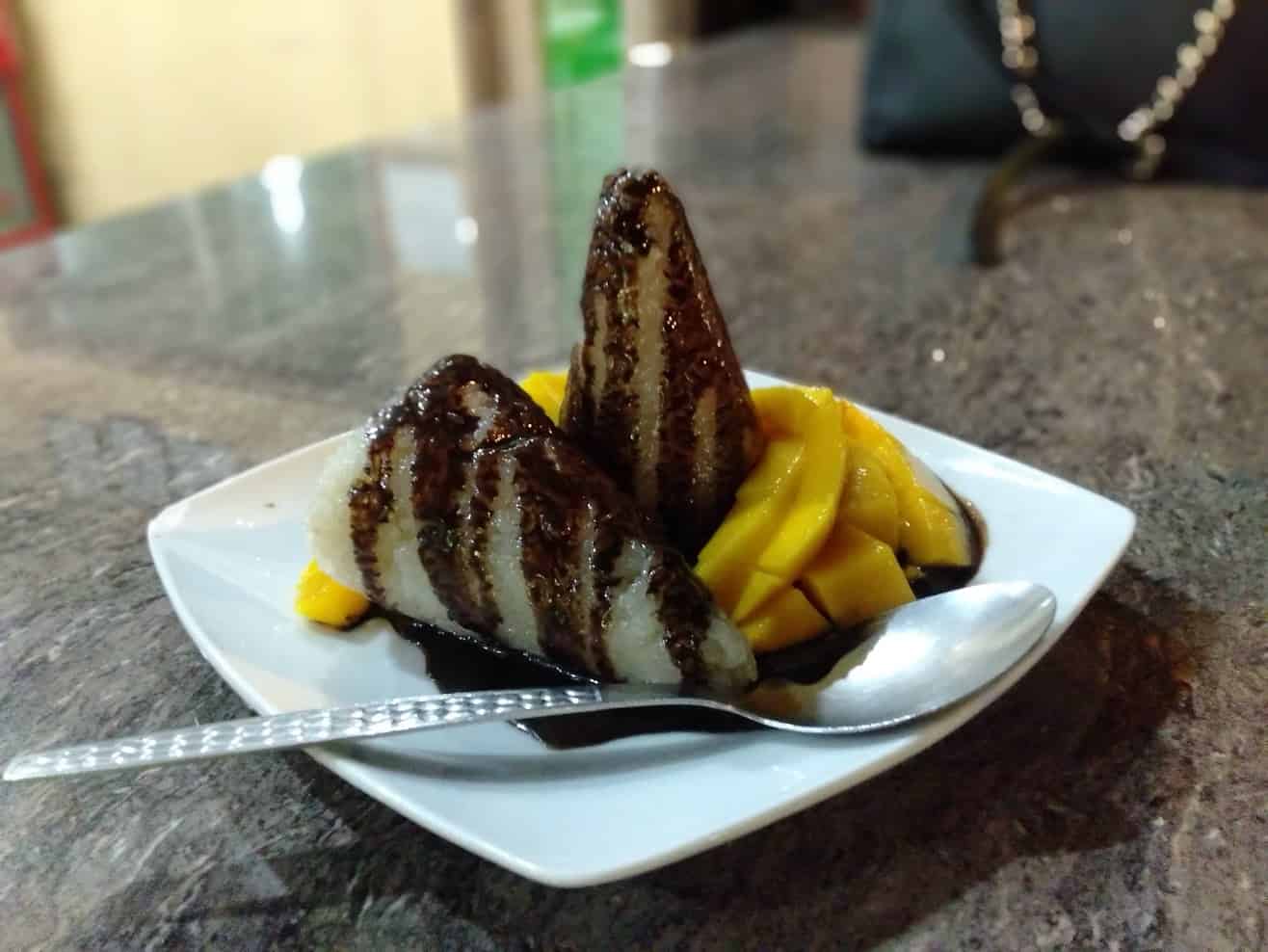 things to do in dumaguete - Things to Do in Dumaguete: A Traveler’s Guide to the City of Gentle People Sticky rice with sugar, coconut milk, pure cocoa syrup, and mango in the public market.
